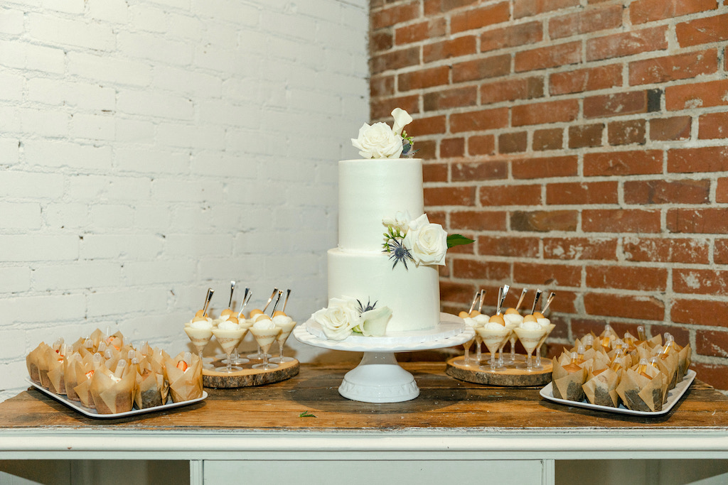 Wedding cake on dessert table at factory wedding venue