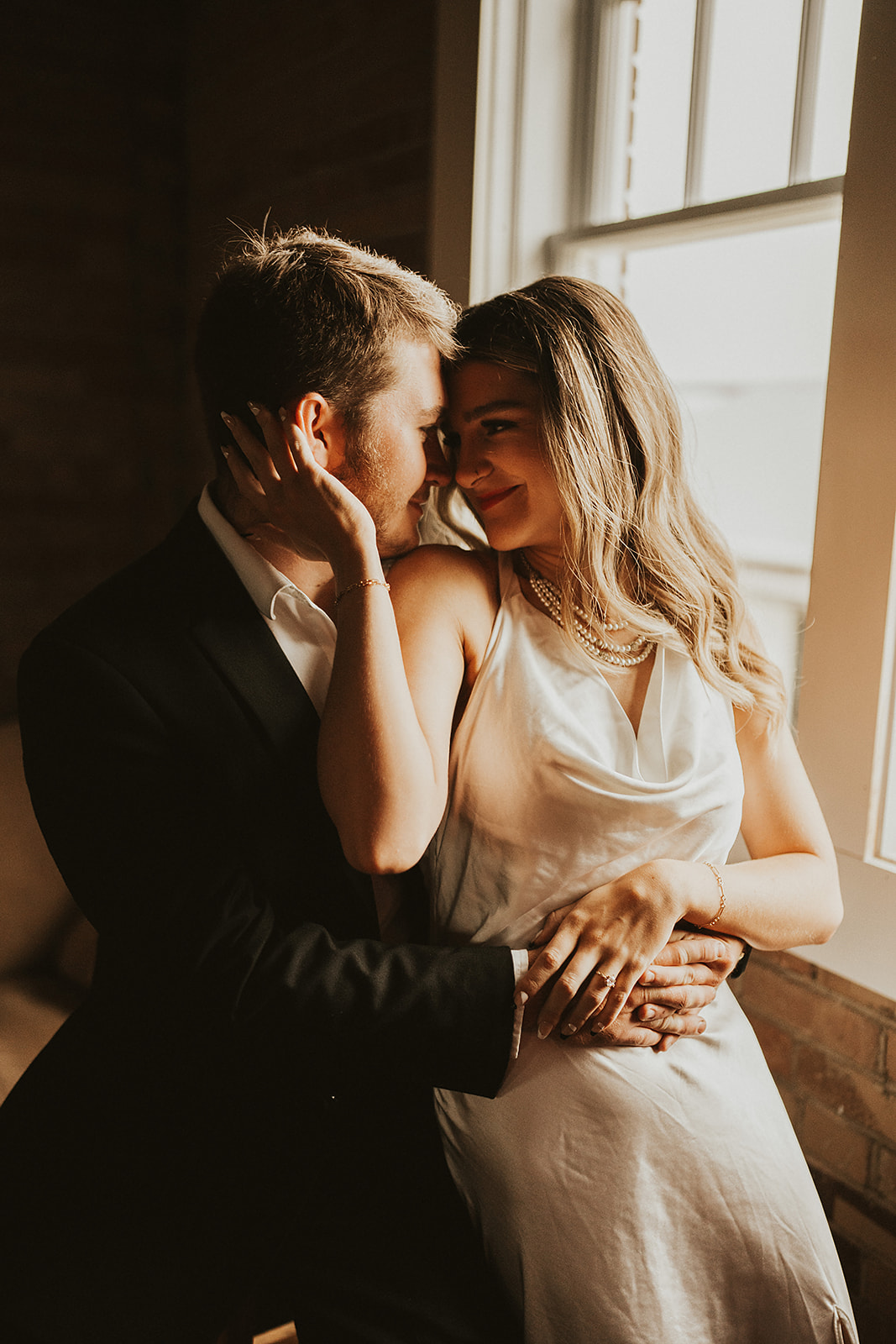 Bride and groom posing on the floor in front of a brick wall in north georgia