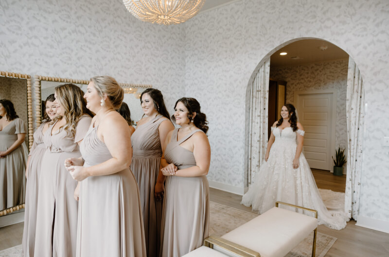 Bridesmaid's first look at bride in bridal suite