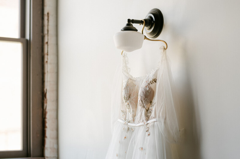 Wedding dress hanging on industrial light in Gainesville wedding venue